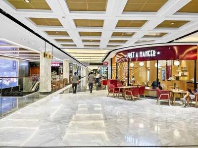 a mall with tables and chairs and people walking through it at FIRST CLASS 1BR Stunning Burj Khalifa Views in Dubai