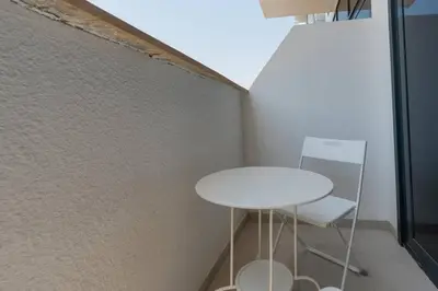 a white table and chair in a room with a wall at 12 min from downtown - Studio - Azizi Riviera in Dubai