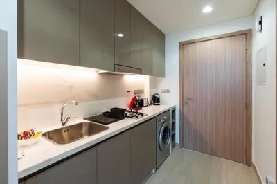 a kitchen with a sink and a washing machine at 12 min from downtown - Studio - Azizi Riviera in Dubai