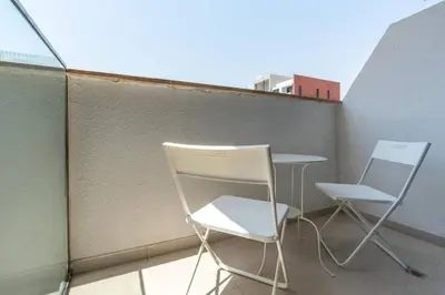 two chairs and a table on a balcony at 12 min from downtown - Studio - Azizi Riviera in Dubai