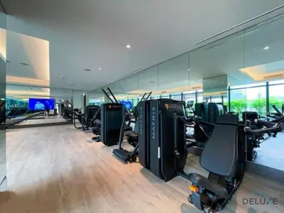 a gym with a row of treadmills and exercise bikes at Elegant 2BR Apartment at The Address Residences Dubai Opera, Downtown Dubai by Deluxe Holiday Homes in Dubai