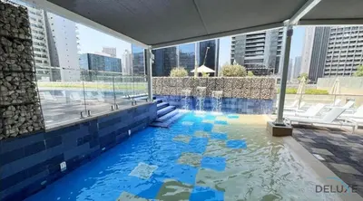 a swimming pool in the middle of a building at Calm 1BR in Vera Tower, Business Bay by Deluxe Holiday Homes in Dubai
