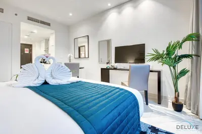 a bedroom with a bed with two swans on it at Charming Studio in Celestia A, Dubai South by Deluxe Holiday Homes in Dubai