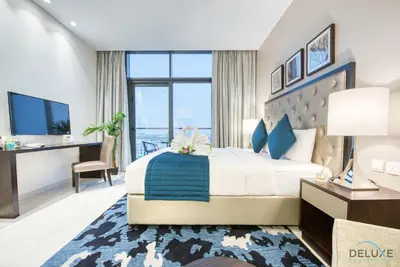 a hotel room with a large bed and a desk at Charming Studio in Celestia A, Dubai South by Deluxe Holiday Homes in Dubai