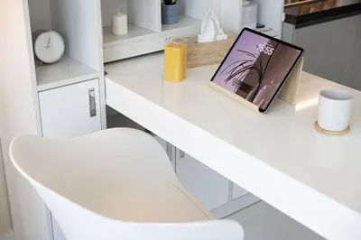a white desk with a chair and a book on it at Studio - Miraclz Tower in Arjan in Dubai