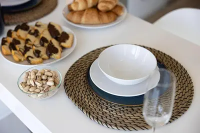 a table with plates of pastries and bowls of nuts at Studio - Miraclz Tower in Arjan in Dubai