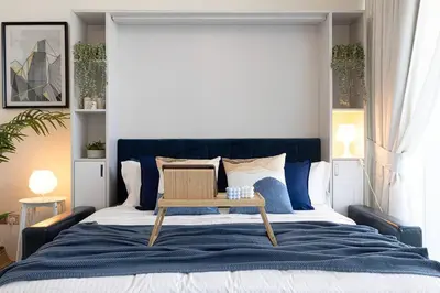 a bedroom with a large bed with a table on it at Studio - Miraclz Tower in Arjan in Dubai