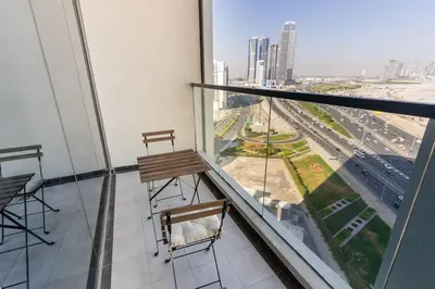 a balcony with two chairs and a view of a city at Comfy Studio in Business Bay l Stays 2 in Dubai
