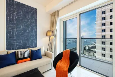 a living room with a couch and a large window at Luxe Sea View High Floor 1 BR in Dubai Marina by Maxx Value Homes in Dubai