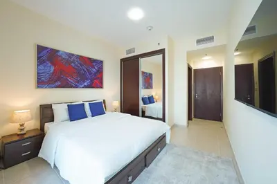 a bedroom with a large white bed and a television at Lux 2BD apartment, Steps to the Beach in the Heart of Dubai Marina - Elite Residence Tower in Dubai