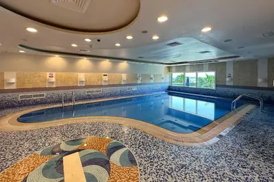a large swimming pool in a large building at Lux 2BD apartment, Steps to the Beach in the Heart of Dubai Marina - Elite Residence Tower in Dubai