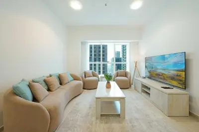 a living room with a couch and a flat screen tv at Lux 2BD apartment, Steps to the Beach in the Heart of Dubai Marina - Elite Residence Tower in Dubai