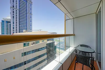 a balcony with a table and chairs on a building at Lux 2BD apartment, Steps to the Beach in the Heart of Dubai Marina - Elite Residence Tower in Dubai