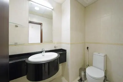 a bathroom with a sink and a toilet and a mirror at Lux 2BD apartment, Steps to the Beach in the Heart of Dubai Marina - Elite Residence Tower in Dubai