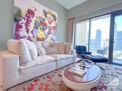 a living room with a white couch and a large window at Prestigious Burj Royale luxury Apartments Downtown in Dubai
