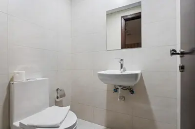 a white bathroom with a toilet and a sink at Modern 1 bedroom apartment in Sports City in Dubai