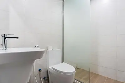 a white bathroom with a toilet and a sink at Modern 1 bedroom apartment in Sports City in Dubai