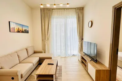 a living room with a couch and a flat screen tv at Modern One Bedroom JVC in Dubai