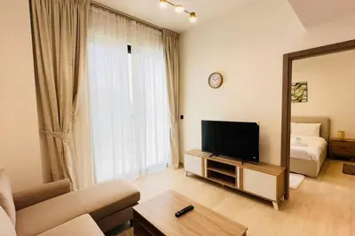 a living room with a television and a mirror at Modern One Bedroom JVC in Dubai