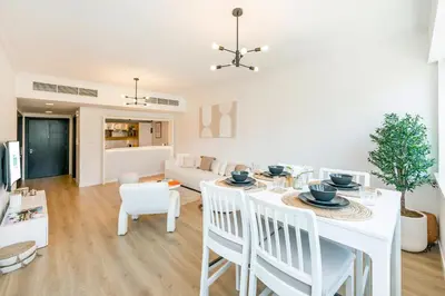 a kitchen and living room with a white table and chairs at FAM Living - Panoramic Dubai Marina View apartment in Dubai