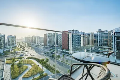 a table on a balcony with a view of a city at Appealing Studio Apartment at Azizi Riviera 34, Al Merkadh by Deluxe Holiday Homes in Dubai