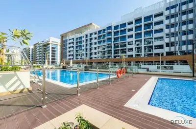 a swimming pool in front of a large building at Appealing Studio Apartment at Azizi Riviera 34, Al Merkadh by Deluxe Holiday Homes in Dubai