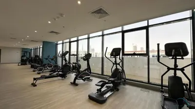 a gym with treadmills and exercise bikes in a building at Appealing Studio Apartment at Azizi Riviera 34, Al Merkadh by Deluxe Holiday Homes in Dubai
