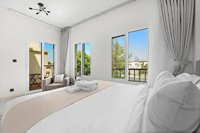 a white bedroom with a large white bed and windows at Stonetree - The Springs 5 - Peaceful Community in Dubai
