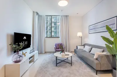 a living room with a couch and a tv at STAY BY LATINEM Luxury 1BR Holiday Home CV B803 near Burj Khalifa in Dubai