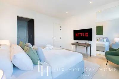a white living room with a couch and a tv at LUX The Bonnington JLT Suite in Dubai
