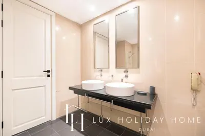 a bathroom with two sinks and a mirror at LUX The Bonnington JLT Suite in Dubai