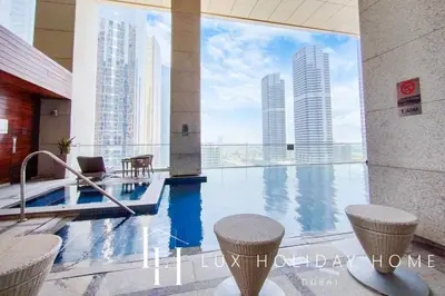 a pool in a building with a view of skyscrapers at LUX The Bonnington JLT Suite in Dubai