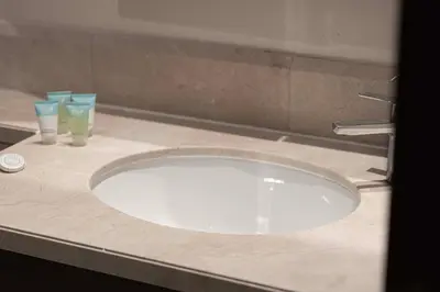 a bathroom sink with two glasses on a counter at Lux 1BR,5 Min to Burj Khalifa In heart of Downtown - South Ridge Tower in Dubai