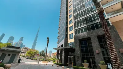 a palm tree in front of a tall building at Lux 1BR,5 Min to Burj Khalifa In heart of Downtown - South Ridge Tower in Dubai