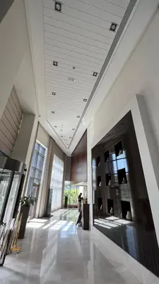 a person walking through a lobby of a building at Lux 1BR,5 Min to Burj Khalifa In heart of Downtown - South Ridge Tower in Dubai