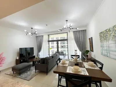 a dining room and living room with a dining table at Luxurious New Brand 2Br at Mulberry 2 at Park Heights Building A2 - Dubai Hills in Dubai