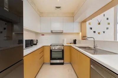 a kitchen with white cabinets and a stove top oven at GLOBALSTAY Creek Rise Tower Elegant Apartments in Dubai