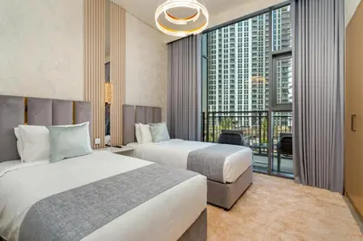 two beds in a hotel room with a large window at GLOBALSTAY Creek Rise Tower Elegant Apartments in Dubai