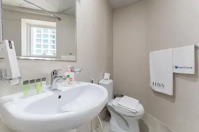 a bathroom with a sink and a toilet and a mirror at HAVN - Studio with Lake Views in Dubai Gate, JLT in Dubai