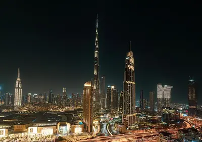 a city skyline at night with a tall building at Downtown Burj Khalifa View 2BR Apartment in Dubai