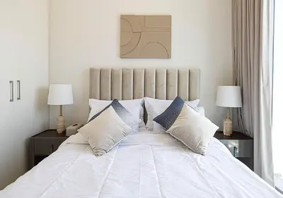 a bedroom with a white bed with two lamps at Downtown Burj Khalifa View 2BR Apartment in Dubai