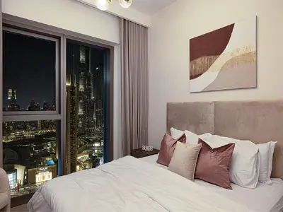 a bedroom with a bed with a view of a city at Downtown Burj Khalifa View 2BR Apartment in Dubai