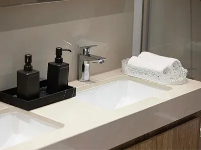 a bathroom sink with two soap dispensers on it at Downtown Burj Khalifa View 2BR Apartment in Dubai