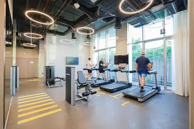 a group of people running on treadmills in a gym at Burj Khalifa view & Creek sea view in Dubai