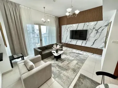 a living room with a couch and a tv at Golden Hour Marina View in Dubai