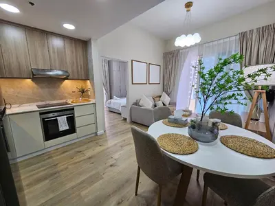 a kitchen and living room with a white table and chairs at Golden Hour Marina View in Dubai