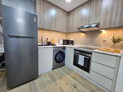 a kitchen with a refrigerator and a washing machine at Golden Hour Marina View in Dubai