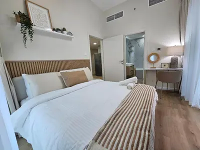 a bedroom with a large bed and a desk at Golden Hour Marina View in Dubai
