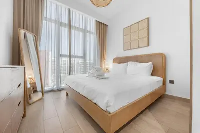 a bedroom with a bed and a large window at Zen Condo With Burj Khalifa View In Vibrant City in Dubai