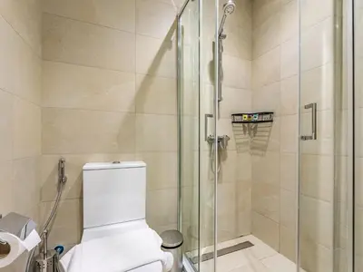 a bathroom with a toilet and a glass shower at Zen Condo With Burj Khalifa View In Vibrant City in Dubai